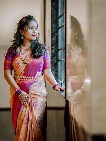 A thoughtful bridal portrait, with the bride looking out a window, her reflection visible.