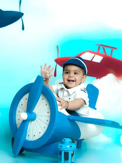 Let your child's imagination take flight with a themed photoshoot. This little one is ready for takeoff in our adorable pilot costume and airplane prop, set against a sky full of adventure.