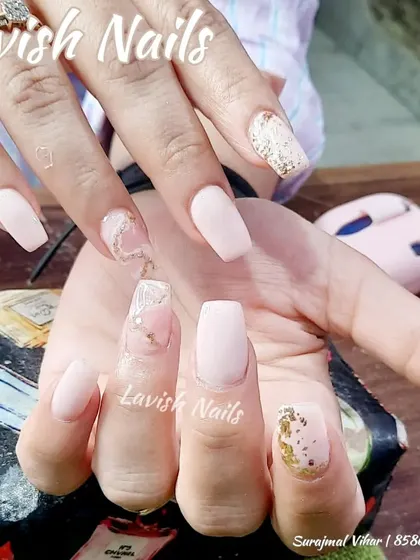 A soft and pretty set with matte pink nails, gold glitter, and accent nails with a delicate, smoky white design and gold foil.