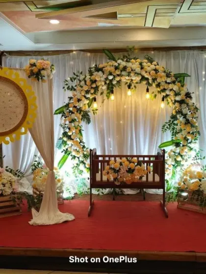 For this naming ceremony, I created a serene and beautiful space. The centerpiece is a traditional wooden cradle, framed by a lush floral arch of peach and white roses, with soft lighting to create a warm glow for the baby's big day.