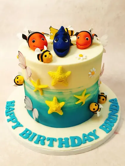 We just keep swimming with this delightful Finding Dory cake. The design features an ocean-blue ombre effect, with Dory, Nemo, and friendly bees creating a whimsical "surf and turf" scene that is both unique and playful.