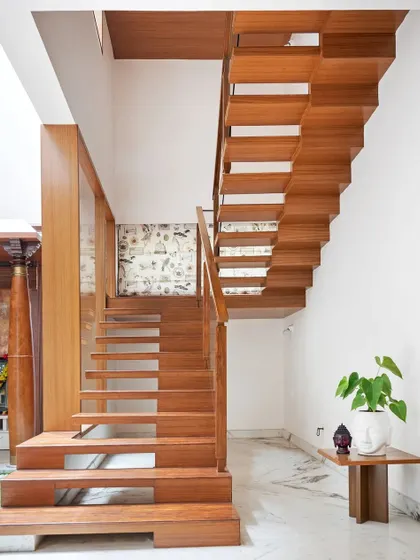 The staircase is more than just for circulation; it's a sculptural element. We used solid wood for the treads to create a floating effect, with the design ensuring views of the courtyard are never obstructed.