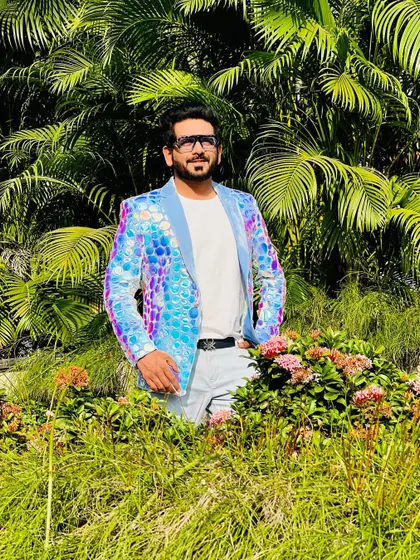 A shimmering, iridescent blue jacket for a poolside carnival. The sequined fabric catches the light beautifully, making it a perfect party outfit.