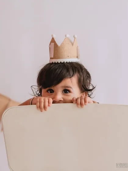 Sometimes the best moments are the unplanned ones. This playful peek-a-boo shot captures the cheeky, giggly side of childhood that we love, turning a simple moment into a precious memory.