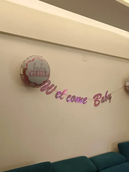 Simple yet sweet wall decor for a baby girl's welcome. A "Welcome Baby" banner flanked by "Baby Girl" foil balloons is an easy way to add a celebratory touch to any room.