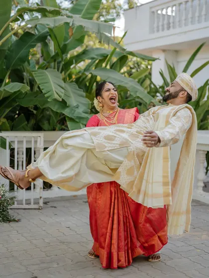 A fun and playful moment where the bride lifts the groom. We love capturing the unique personalities and humor of our couples, showing that weddings are all about joy.