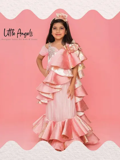 This jacquard drape saree in pink and gold features dramatic ruffles, offering a high fashion take on ethnic wear.