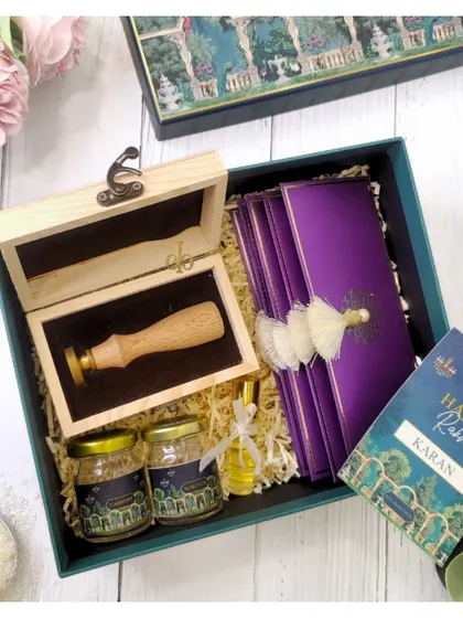 This luxurious Rakhi hamper features a custom wax seal stamp, gourmet honey jars, and elegant purple envelopes, perfect for a sibling who appreciates fine details.