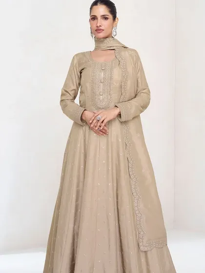 This beige premium silk gown is the definition of understated elegance. The delicate thread embroidery and sequins add a touch of sparkle, making it perfect for a reception or evening party.