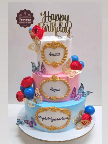 A three-tier cake designed for a family celebrating three birthdays together. Each tier is personalized with a name in a golden frame, tied together with a beautiful floral and butterfly theme.