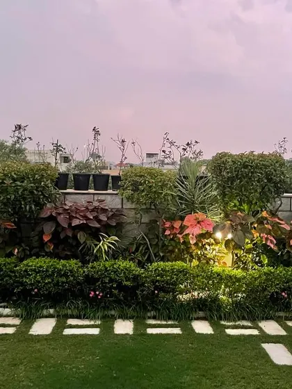 After a hot summer day, a garden is a promise of a pleasant evening. This terrace garden, with its layered hedges, path of stone pavers, and soft lighting, is a perfect example of a tranquil green oasis.