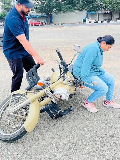 Demonstrating how to recover from a drop. This practical skill is essential for building a rider's self-reliance and overcoming the fear of handling a heavy bike.