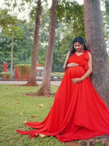 This simple yet elegant red one-bow maternity gown is perfect for a comfortable and beautiful photoshoot in the park. The flowing fabric drapes beautifully over the baby bump.