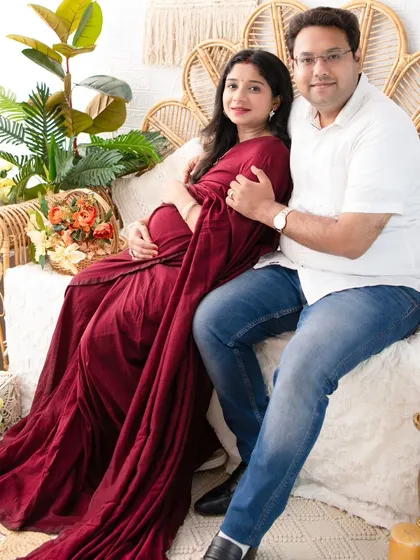 A cozy and loving portrait of the couple seated on our boho-style daybed. Their comfortable embrace and the warm tones of the set create a feeling of home.