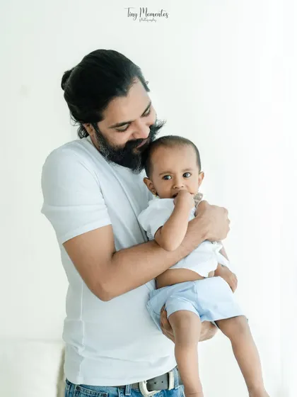 A father's gentle embrace. This close-up portrait focuses on the secure and loving bond between a dad and his baby boy, a truly heartwarming moment.