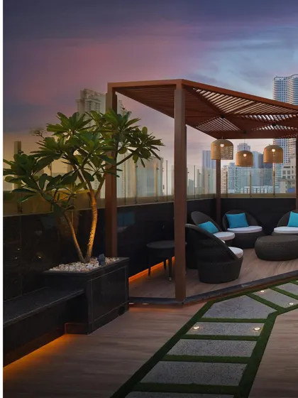 Another view of the rooftop lounge at our Lower Parel residential project. The wooden pergola and ambient lighting create a warm and inviting atmosphere, making it an ideal space for evening gatherings.