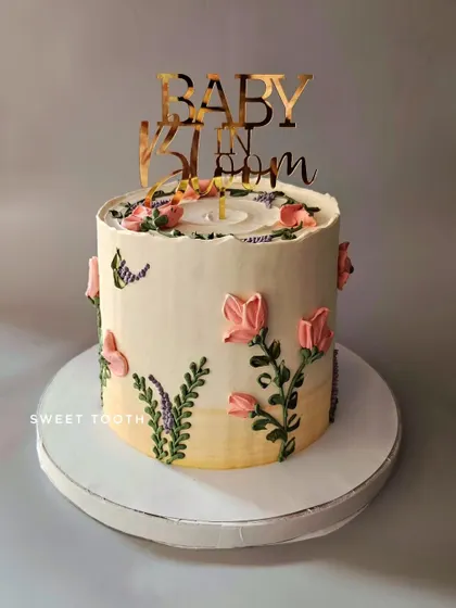 Baby in bloom. A beautiful floral cake for a baby shower, decorated with buttercream flowers in a delicate, painted style. This one was a chocolate and biscoff cake.