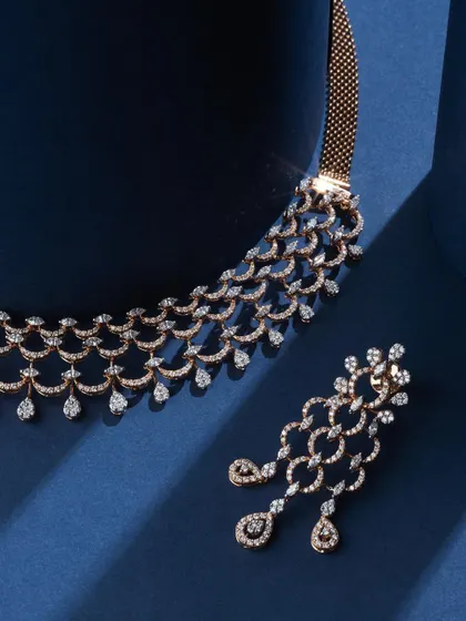 There's something about a clean blue background and sparkling diamonds. This shot for Ranka Jewellers focuses on the intricate, cascading design of the diamond necklace and earrings, with the deep blue silk adding a touch of royalty.