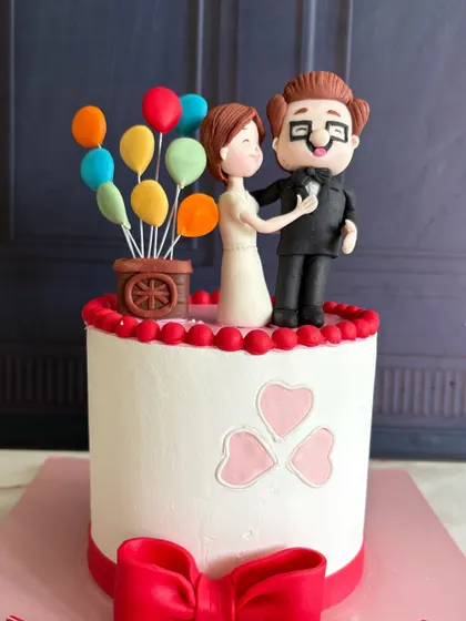 A close-up of the adorable, hand-sculpted Carl and Ellie toppers, complete with their colorful balloons.