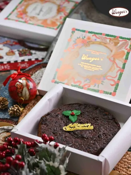 Unboxing a Wenger's Christmas Plum Cake is the start of a celebration. Decorated with a simple holly leaf, this cake is packed with rum-soaked fruits and nuts, ready to be shared.