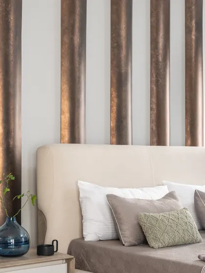A close-up of the curved, metallic-finish panels behind the bed. This detail shot highlights the texture and light play that adds depth and a touch of understated luxury to the master bedroom.