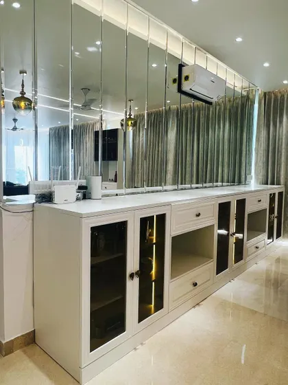A wide view of the custom crockery unit in Vatika City, Gurugram. The mirrored wall above it doubles the visual space and reflects light beautifully.