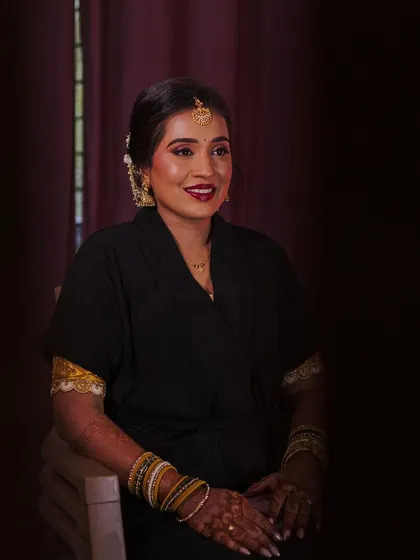 A dramatic "getting ready" shot of the beautiful bride Dhanya. The lighting creates a moody and artistic feel.