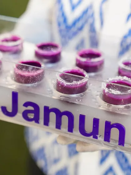 A beautifully presented tray of our vibrant purple Jamun Shots, a unique and healthy welcome drink for any event.