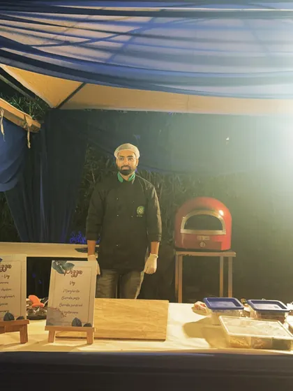 A simple and elegant setup for an evening party. The dark blue canopy and warm lighting create a sophisticated ambiance for my live pizza station.