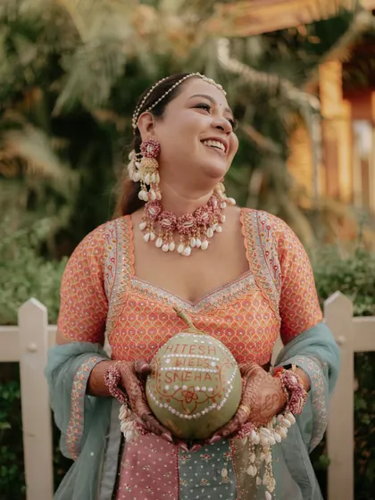 The bride's joyful expression as she holds the ceremonial coconut, a perfect candid moment.