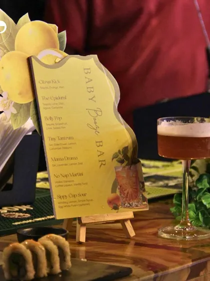 A custom-designed 'Baby Booze Bar' menu for a citrus-themed shower, featuring creatively named mocktails. This is a fun way to carry the theme through to the food and beverage service.