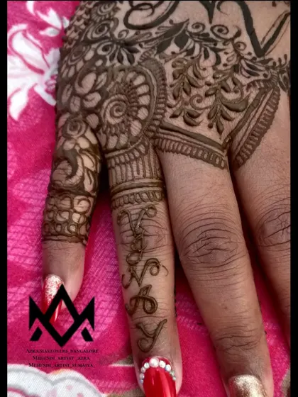 A creative way to include initials in your mehendi, with the letters 'V', 'N', 'A', and 'Y' hidden within the finger design.