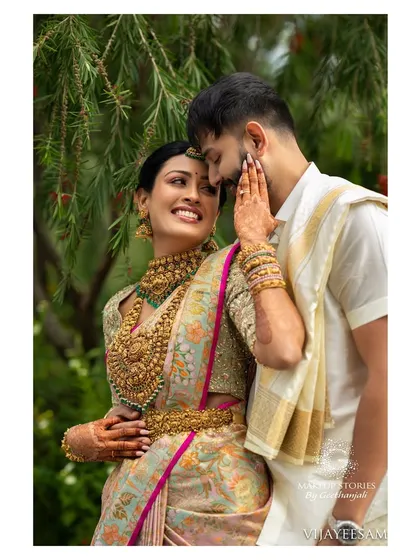 An adorable moment between Ashitha and her partner. Her makeup is natural and glowing, ensuring her happiness is the main focus of this beautiful wedding portrait.