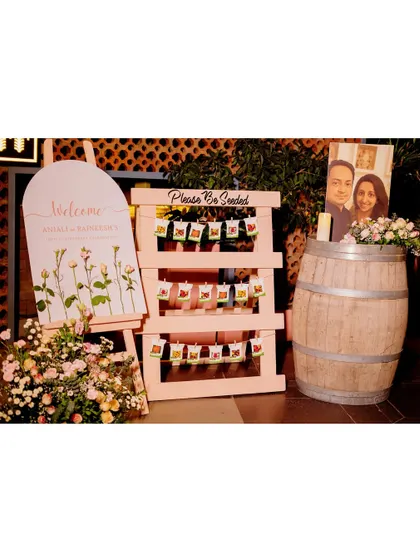 A clear view of the welcome and seating station, showcasing the personalized details like the couple's photo and the coordinated floral arrangements.