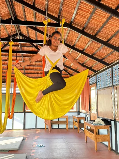 A smiling student enjoys the gentle sway of the hammock, finding a moment of peace and happiness mid-air.
