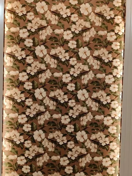 A dense floral wallpaper with large white blossoms on a brown background. This design is used as an accent panel, adding a bold and beautiful touch to the wall.