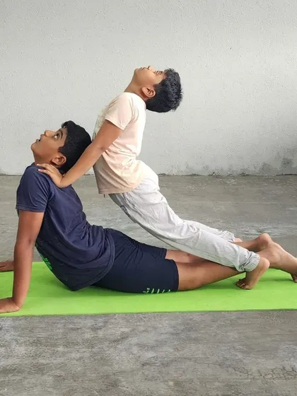 This partner pose demonstrates great strength from the base and excellent body tension from the flyer, creating a solid, elevated plank.