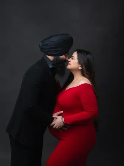 A classic, intimate pose. The couple, dressed in elegant red and black, share a moment of connection in this sophisticated studio portrait.