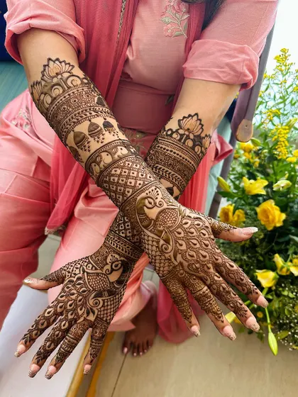 A beautiful full-arm design with peacocks on the palms and intricate bands of elephants and jhumkas on the arms.