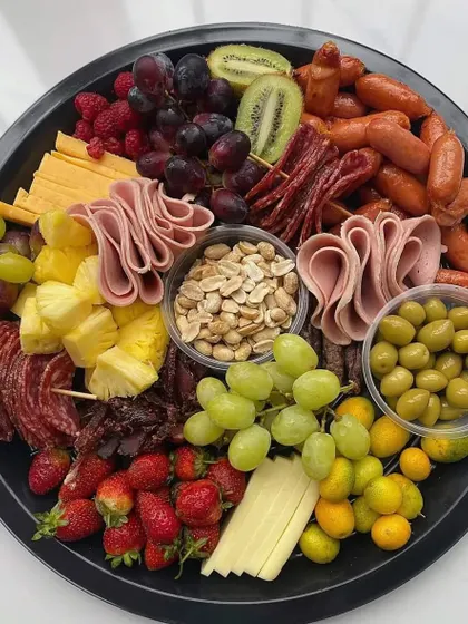 A classic charcuterie and cheese platter. Perfect for cocktail hours, it features an assortment of cured meats, cheeses, fruits, nuts, and olives.