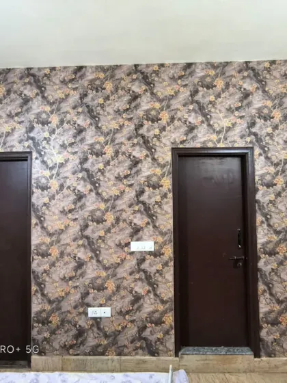A full wall view of the dark floral wallpaper, installed between two doors.
