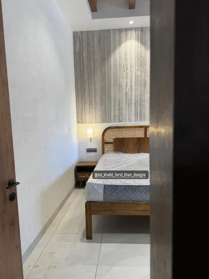 A peek into one of the hotel rooms, revealing the carefully crafted bed and nightstand that create a welcoming and stylish environment for guests.