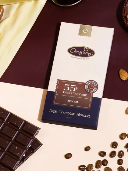 A premium, styled flatlay for a dark chocolate almond bar. The geometric background and carefully placed coffee beans and almonds create a sophisticated look, perfect for a luxury confectionery brand.