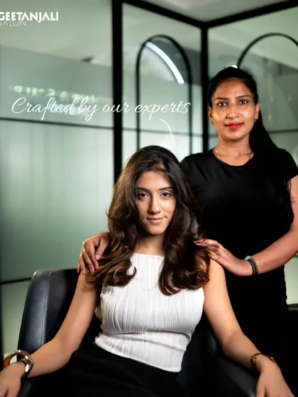 Crafted by our experts. A client poses with her stylist, showing the personal connection and expert care that goes into every service.