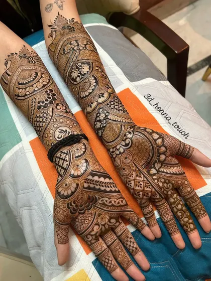 A stunning pair of hands with full bridal mehndi. The designs are rich and dense, featuring peacocks, paisleys, and a variety of traditional patterns for a grand look.
