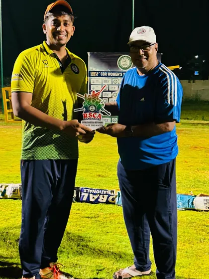 A player receives an award for his performance in a night match during the RSCA Dasara Cup.