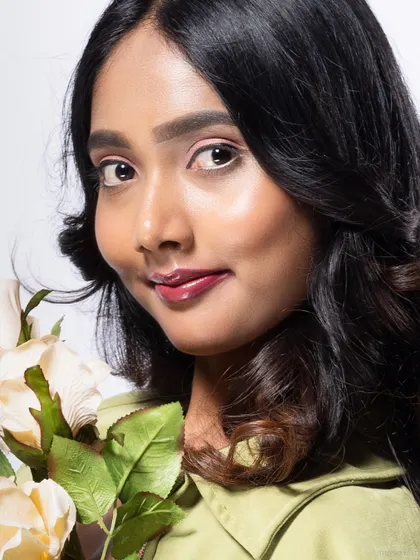 A close-up of a model holding roses, with a soft and engaging expression.