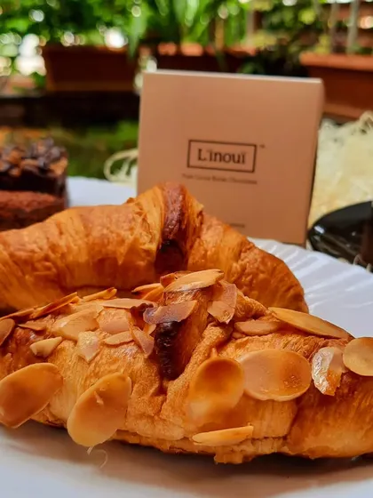 A beautiful spread of our treats, including almond croissants and pastries, enjoyed in a garden setting. This is the experience we hope to provide, a taste of luxury made right here in namma Bengaluru.