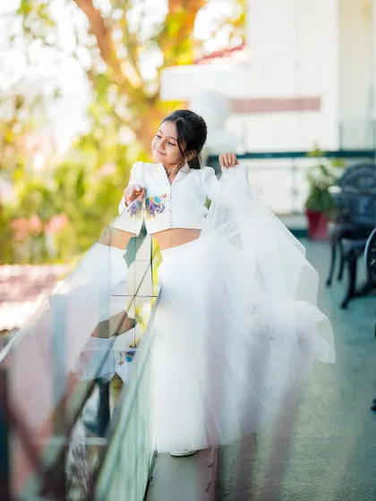 A beautiful, artistic shot of a young girl in a white outfit, her movement creating a lovely blur. We love capturing these moments of youthful energy.