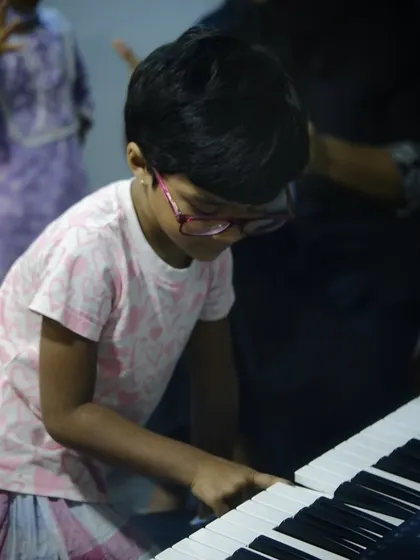 A young student gets hands on with the keyboard. Our classes are interactive and designed to keep our youngest learners engaged.